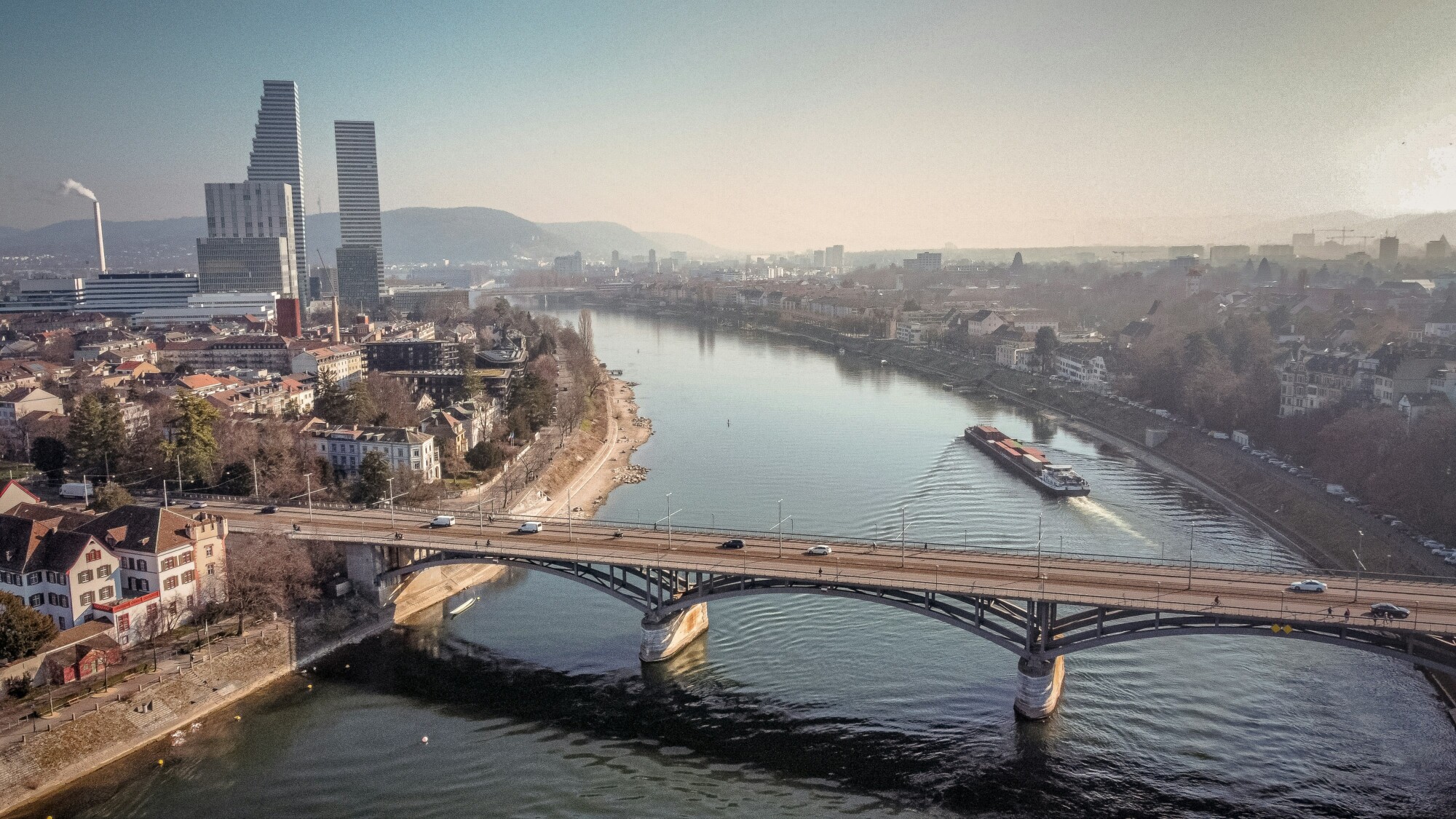 Es ist ein Ausschnitt der Stadt Basel zu sehen. Mit dem Rhein und einer Brücke über den Rhein.