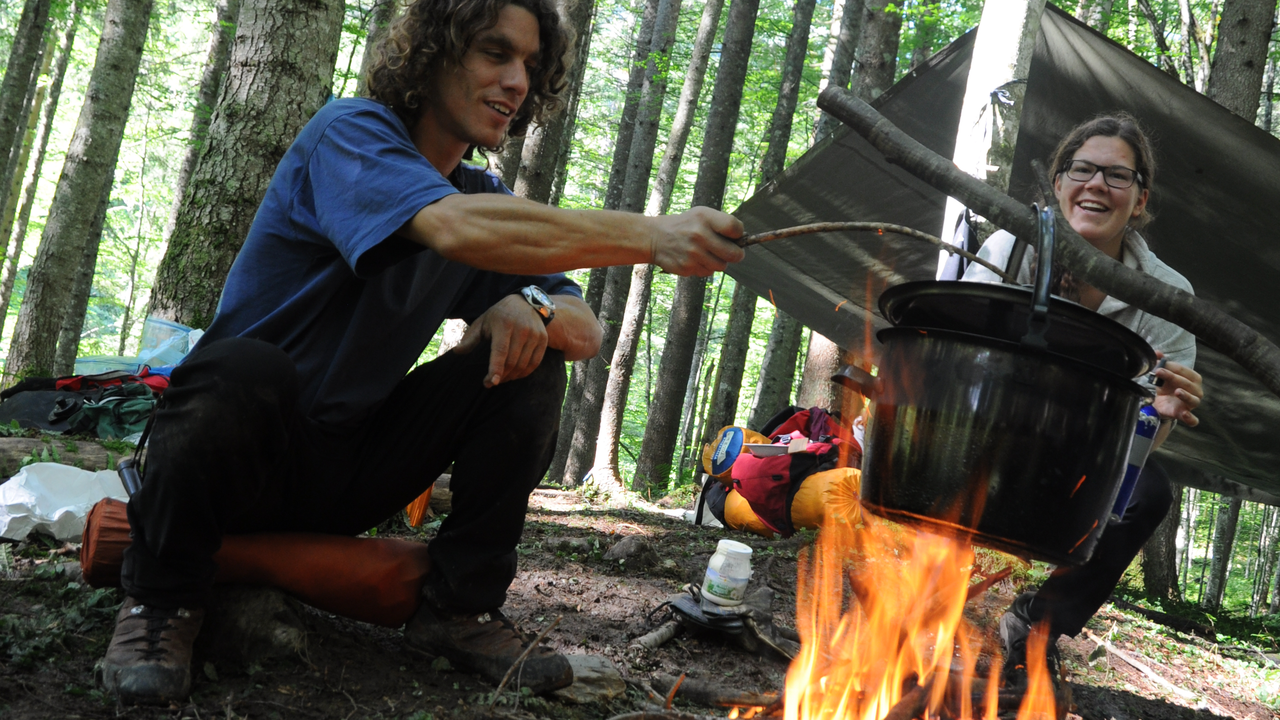 Team-Kochen am offenen Feuer: Finden Sie sich als Team, indem Sie gemeinsam ein leckeres Essen zubereiten.