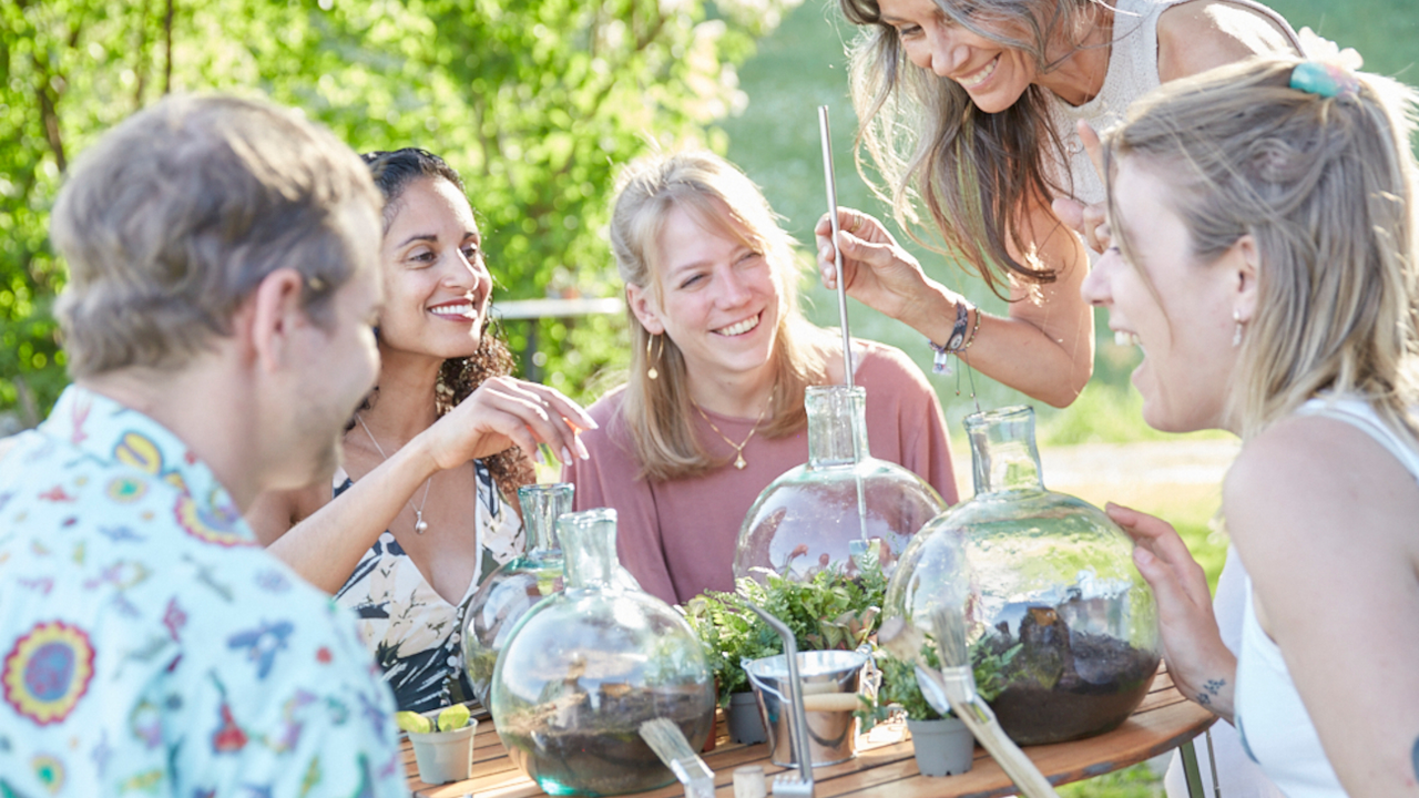 Flaschengarten selber bepflanzen Teamevent Ein geschlossener Flaschengarten ist ein kleines, autarkes Ökosystem im Glas. Er benötigt etwa ein- bis zweimal pro Jahr ein paar Tropfen Wasser. Im Flaschengarten-Workshop bepflanzen die Teilnehmenden ihren eigenen Flaschengarten. Wir zeigen, wie ein Ökosystem im Glas funktioniert, welche Pflanzen dafür geeignet sind und wie sie ins Glas kommen. Das dafür notwendige Spezialwerkzeug stellen wir Ihnen für den Gebrauch im Workshop zur Verfügung. Zudem verraten wir Ihnen Tipps und Tricks beim Bepflanzen eines Flaschengartens sowie für die Pflege danach. Am Ende des Workshops haben alle Teilnehmende eine eigene kleine Welt im Glas zum mitnehmen. Der Flaschengarten auf dem Schreibtisch erinnert auch in Zukunft an den Team-Event.