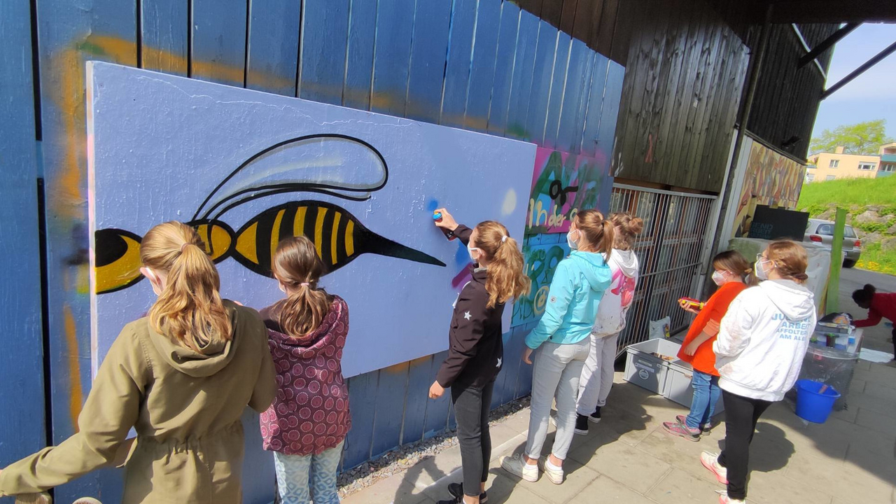 Graffiti Workshop Bei diesem Workshop werden den Teilnehmenden alle nötigen Techniken gezeigt, um an einem Tag das erste eigene Graffiti-Bild an die Wand zu malen. Graffiti-Workshops zu leiten ist meine grosse Leidenschaft. Und das darf sie gerne bleiben. Falls Ihr an einem Ort arbeitet, bei dem Ihr Euch vorstellen könnt, dass ein Graffiti-Workshop gut ankommen könnte, Ihr selbst Interesse an Street Art habt oder fürs nächste Dorffest eine spannende Tätigkeit anbieten möchtet, lasst es mich wissen.