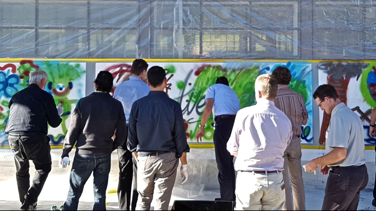 Graffiti Kreativ Event Mit Ihrem Team kreieren Sie ein Spraybild, das zum Motto Ihrer Gruppe passt und Farbe in Ihren Alltag bringt. Eine kurze Einführung in die Handhabung der Materialien und schon kann es losgehen. Kreieren Sie gemeinsam das Unternehmensleitbild oder die neue Vision in Begleitung eines professionellen Graffiti-Künstlers. Ein nicht alltägliches Erlebnis ist garantiert. Am besten kombinieren Sie dieses Erlebnis mit einem Aperitif. Die Kreativität nimmt zu, die Profis werden es Ihnen bestätigen.