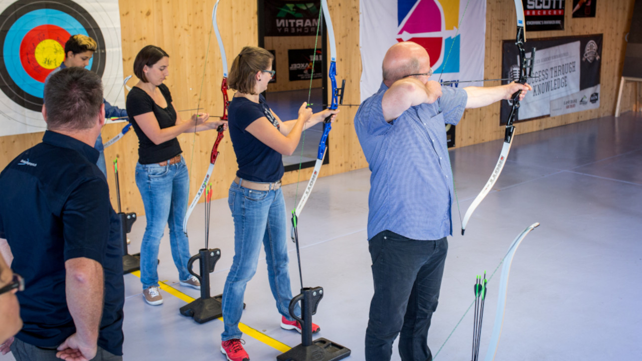Pfeil und Bogen Indoor Ihr Event mit Pfeil und Bogen. Konzentration, bewusste Atmung, kontrollierte Körperhaltung, mentale Stärke, Instinkte und Kondition werden durch das Bogenschiessen gefördert und gestärkt. Mit der Familie, Mitarbeitenden, Vereinskollegen oder Freunden etwas Bogensport-Luft schnuppern? Mit einem Treffer ins Gold das Weihnachtsessen eröffnen oder mit einem Plauschturnier den Vereinsausflug noch spannender gestalten? Wir organisieren individuelle Events mit Bogensport, Armbrust und Blasrohr.