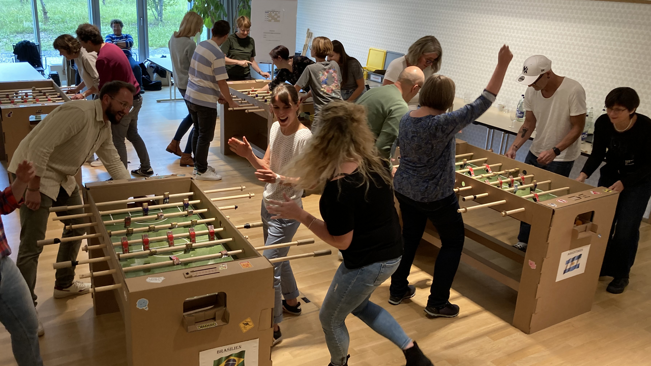Bauen Sie mit Ihrem Team einen oder mehrere Tischfussbal Kästen selber. Der «Töggelikasten» bauen Sie aus Karton Schritt für Schritt selber in diesem Workshop. Auf den stabilen Töggelikasten aus Kartonbausätzen wird im Anschluss ein einzigartiges Turnier gespielt. Dieser Workshop verlangt Geschicklichkeit, logisches Denken und Teamwork.