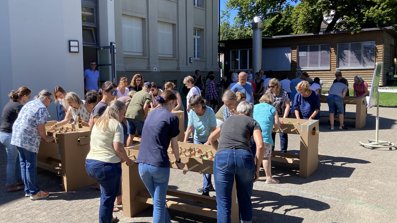 Bauen Sie mit Ihrem Team einen oder mehrere Tischfussbal Kästen selber. Der «Töggelikasten» bauen Sie aus Karton Schritt für Schritt selber in diesem Workshop. Auf den stabilen Töggelikasten aus Kartonbausätzen wird im Anschluss ein einzigartiges Turnier gespielt. Dieser Workshop verlangt Geschicklichkeit, logisches Denken und Teamwork.