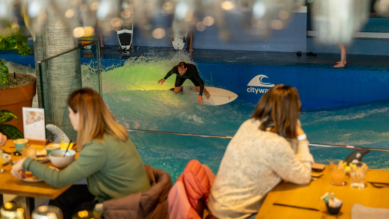 Indoor Surf-Welle mit tropischem Feeling: Im Mittelpunkt der Location befindet sich die stehende Welle, welche sich perfekt für Anfänger und auch erfahrene Surfer eignet. An Ihrem Event steht einem Ritt auf der Welle nichts im Weg. In einer einzigartigen Umgebung kann auch lecker gegessen oder an der Bar gefeiert werden.