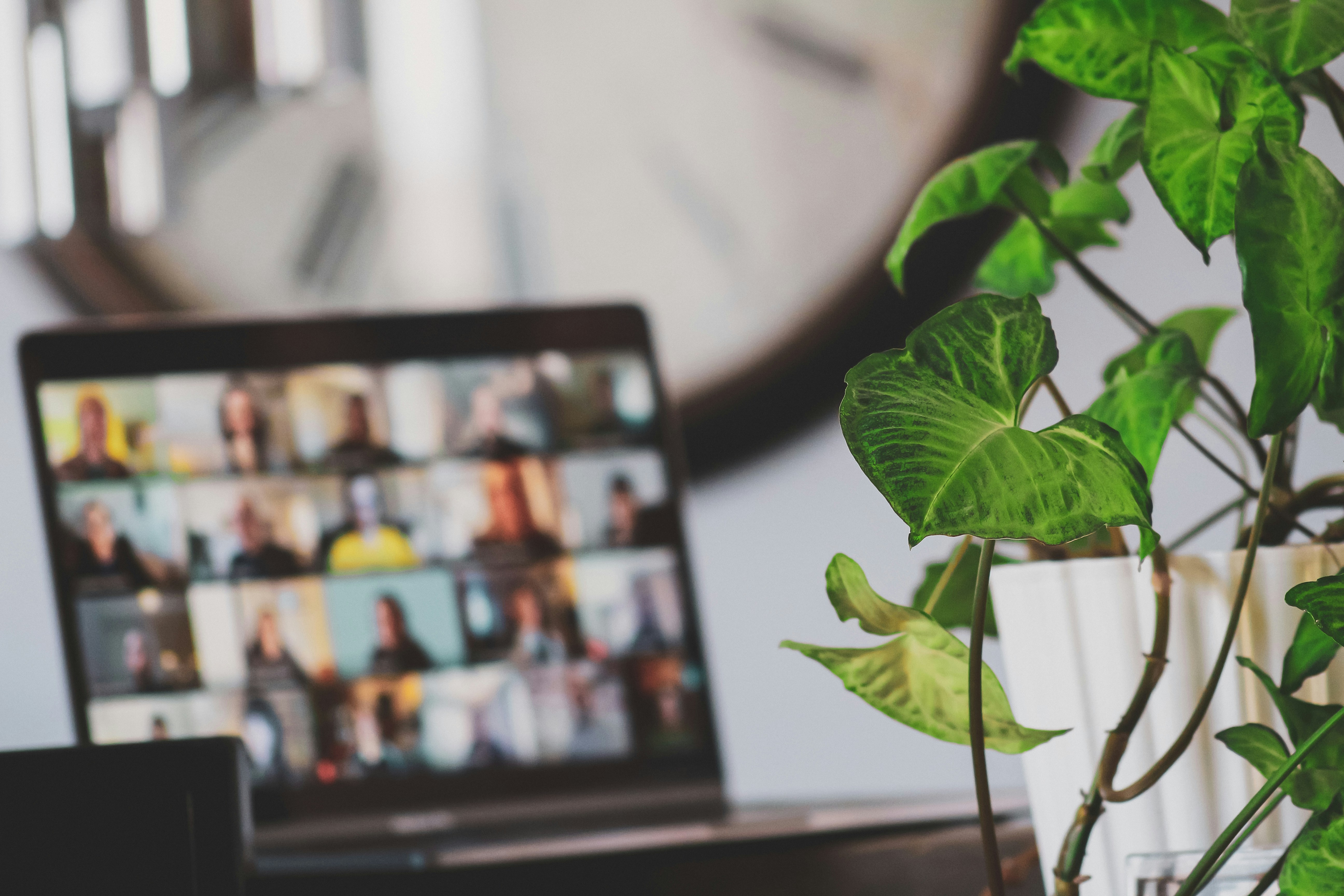Ein Arbeitsplatz im Homeoffice mit einem angedeuteten Teamcall mit vielen Teilnehmenden